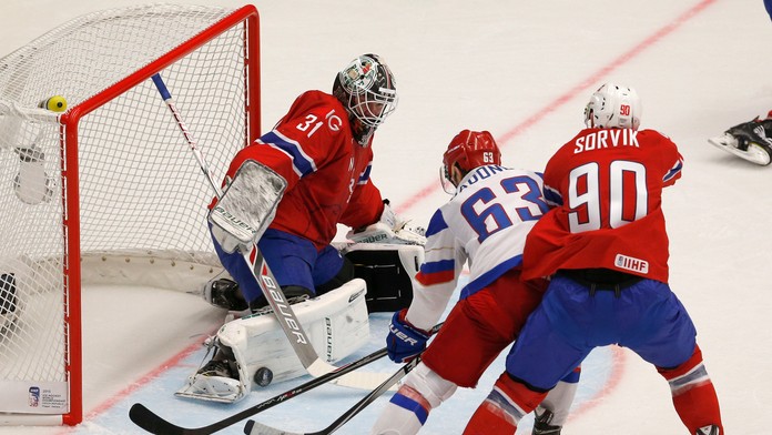 Rus Jevgenij Dadonov sa pokúša doraziť strelu za chrbát nórskeho brankára Larsa Voldena.