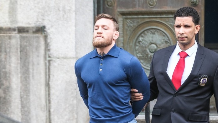 Policajt odvádza McGregora do súdnej siene.