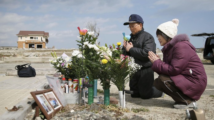 anželia sa modlia za svoju dcéru, ktorá zahynula v roku 2011 počas ničivého cunami v japonskom Namie v profektúre Fukušima.