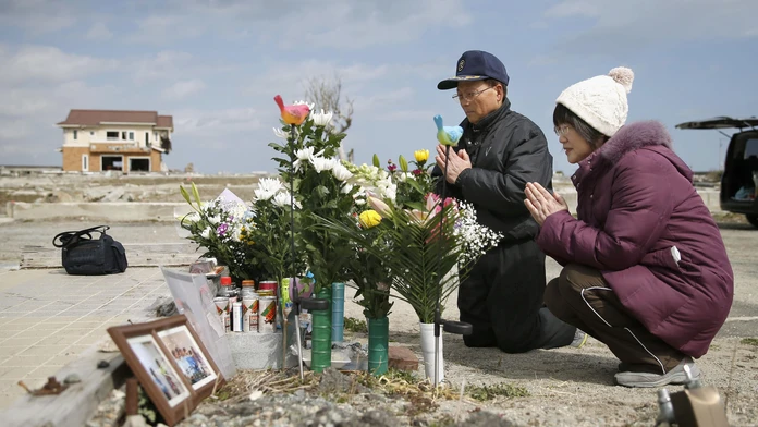 anželia sa modlia za svoju dcéru, ktorá zahynula v roku 2011 počas ničivého cunami v japonskom Namie v profektúre Fukušima.