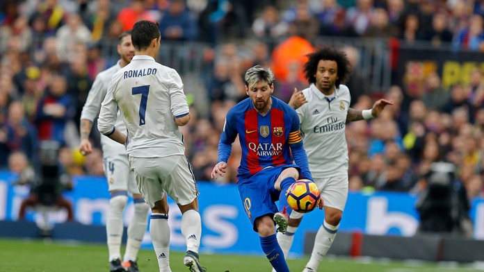 Kapitána Barcelony Lionela Messiho (v strede) sa v El Clásicu snaží obrať o loptu bek Realu Marcelo (vpravo), prizerá sa Cristia