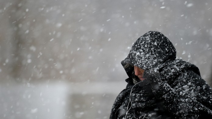 Žena kráča počas hustého sneženia - ilustračné foto