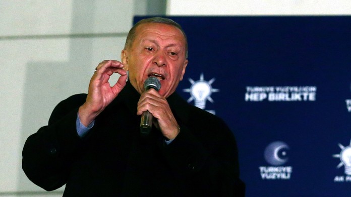 Turecký prezident Recep Tayyip Erdogan s mikrofónom v ruke počas prejavu.