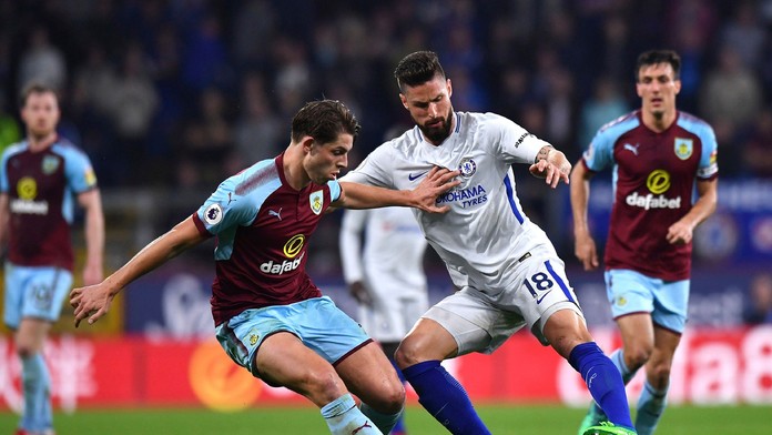 Olivier Giroud (Chelsea) s loptou a dobiedzajúci Mark Tarkowski (Burnley).