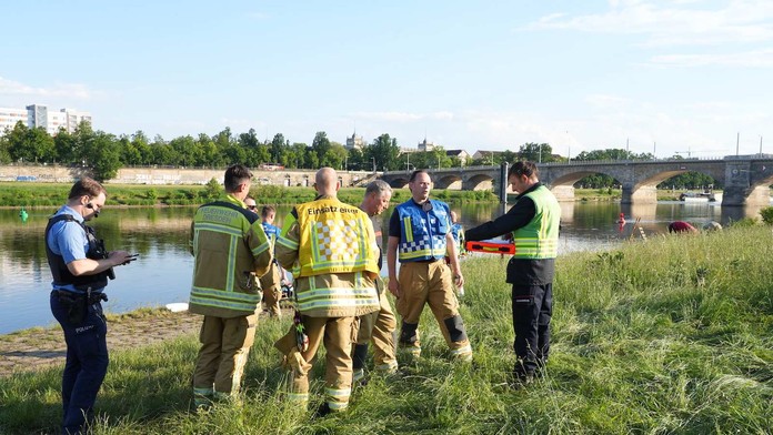 Na snímke hasiči stoja pri brehu rieky Labe v Drážďanoch.