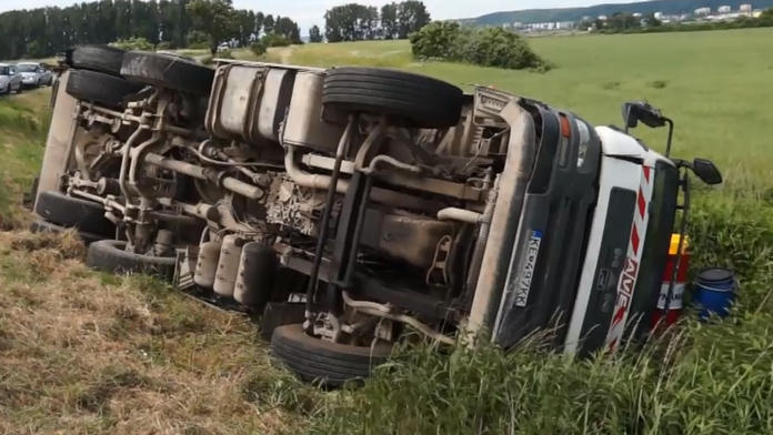 Prevrátené smetiarske vozidlo.