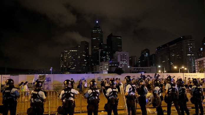 Policajti v Hongkongu zatýkajú počas protestu muža.