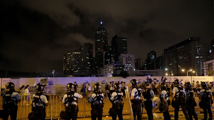 Policajti v Hongkongu zatýkajú počas protestu muža.