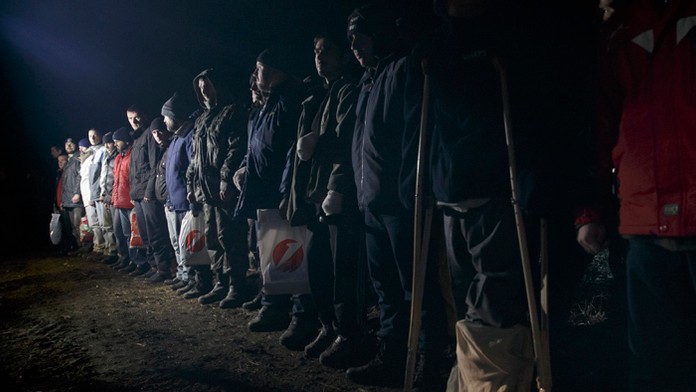 Ukrajinskí vojnoví zajatci stoja v zoradený v rade pred výmenou zajatcov pri  dedine Žolobok.