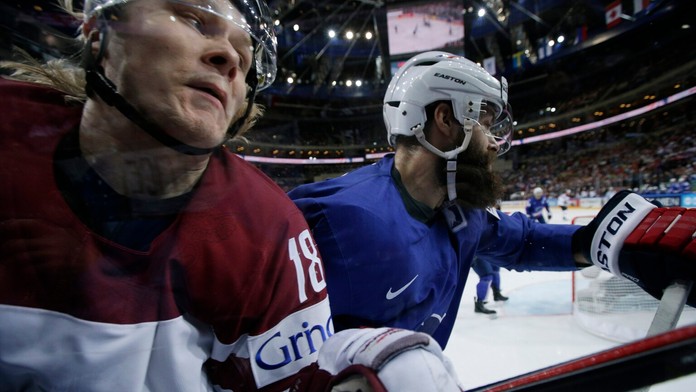 Francúzsky hráč Antonin Manavian (vpravo) naráža lotyšského hráča Rodriga Abolsa na plexisklo