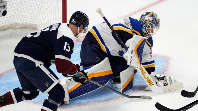 Brankár St. Louis Blues Jordan Binnington (vpravo) kryje puk po tom, čo zastavil strelu pravého krídla Colorada Avalanche Valeriho Nicushkina. 