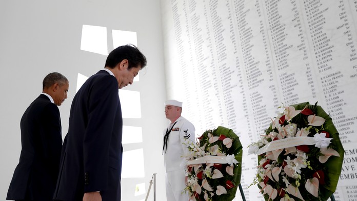 Japonský premiér Šinzó Abe a prezident USA Barack Obama sa skláňajú počas kladenia vencov pri pamätníku nad vrakom lodi Arizona.