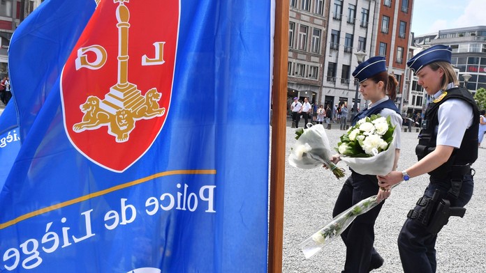 Na snímke dve policajtky kladú kvety počas minúty ticha za obete utorňajšieho útoku 30. mája 2018 v belgickom meste Liege.