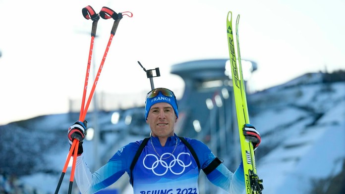 Biatlonista Quentin Fillon Maillet oslavuje zlato vo vytrvalostných pretekoch na ZOH 2022.