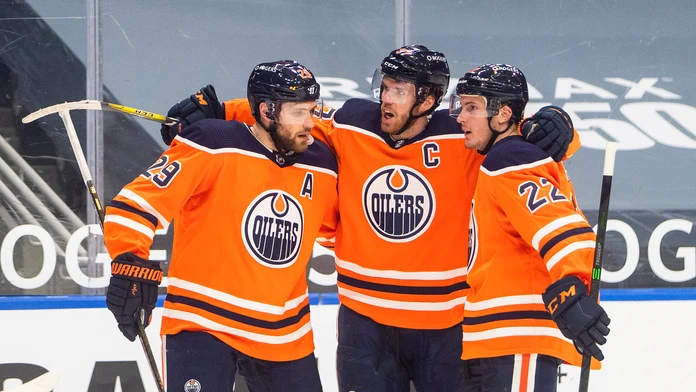 Connor McDavid oslavuje gól so spoluhráčmi Leonom Draisaitlom a Tysonom Barriem.