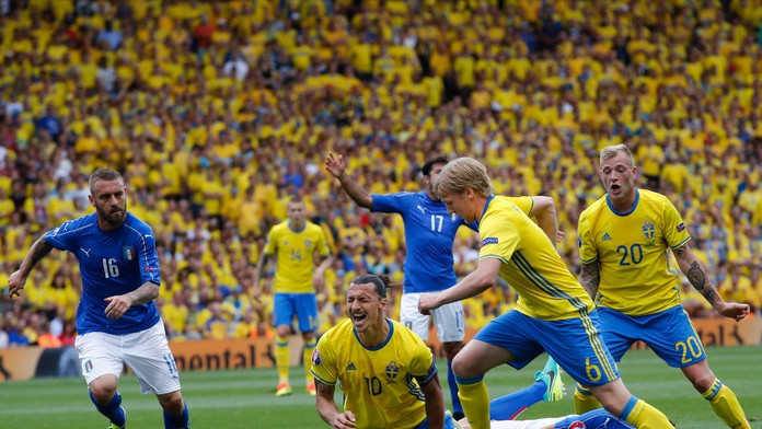 Švédska ikona hráč Zlatan Ibrahimovič padá po kolízii s Talianom Andreou Barzaglim, loptu berie Emil Forsberg.