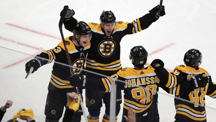 Hokejista Bostonu Charlie Coyle (uprostred) sa teší so spoluhráčmi po strelení víťazného gólu za chrbát brankára Columbusu.
