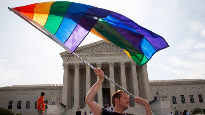 John Becker máva dúhovou zástavou na vyjadrenie podpory homosexuálnych manželstiev pred sídlom Najvyššieho súdu USA vo Washingto