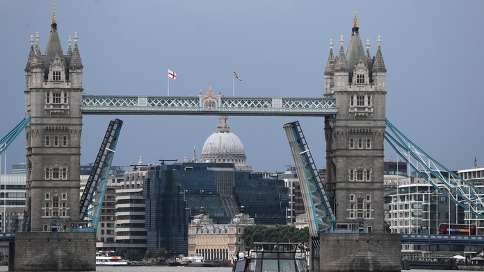Čln pláva na rieke Temža pod zaseknutým zdvíhacím mostom Tower Bridge.