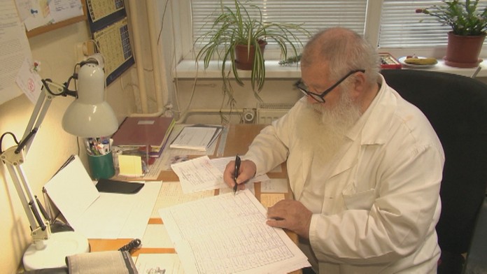 Gruzínski opoziční demonštranti držia poster počas protestného zhromaždenia pred budovou gruzínskeho parlamentu.