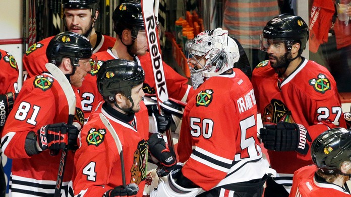 Brankár Chicaga Blackhawks Corey Crawford (50) sa raduje so spoluhráčmi z víťazstva 2:1 nad Minnesotou Wild, vľavo Slovák Marián