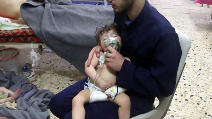 Zdravotník dáva kyslíkovú masku dieťaťu po údajnom chemickom útoku v sýrskom meste Dúma.