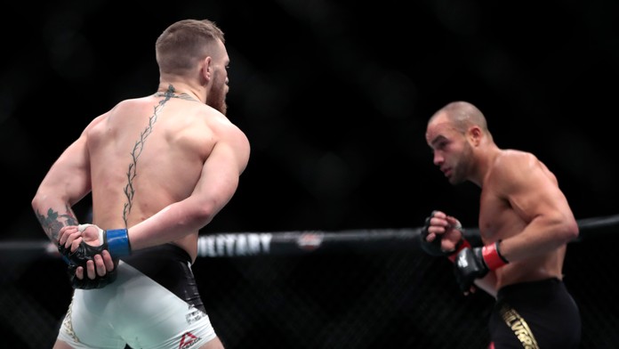 Conor McGregor sa gestom rukami za chrbtom vysmieva protivníkovi Eddiemu Alvarezovi.