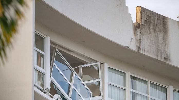 Zničená strecha a okno po páde vrtuľníka na austrálsky hotel Double Tree v meste Cairns.