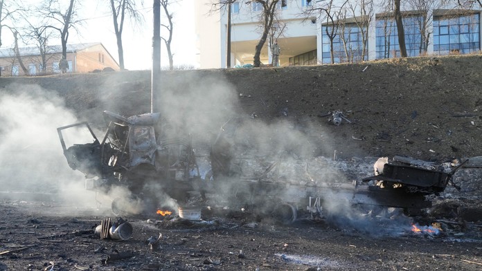 Trosky horiaceho vojenského nákladného auta na ulici v Kyjeve.