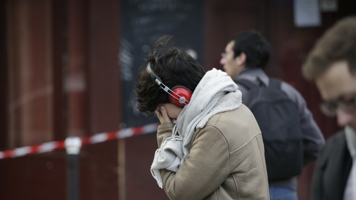 Plačúca žena pred barom Carillon, kde sa odohral jeden z útokov.