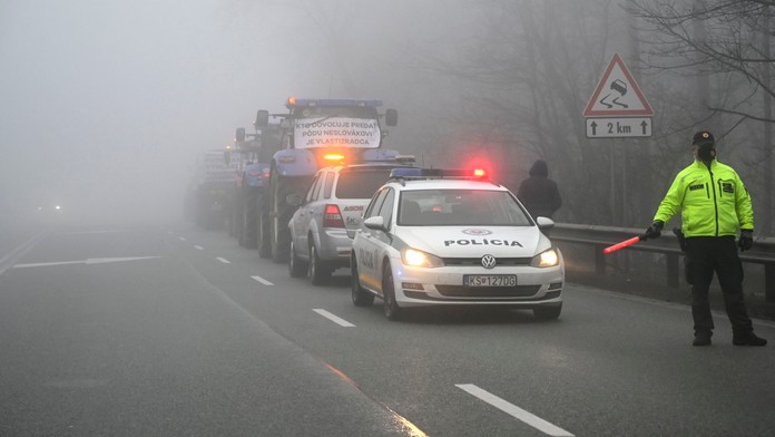 Policajt riadi premávku počas blokovania horského priechodu Dargov farmármi.