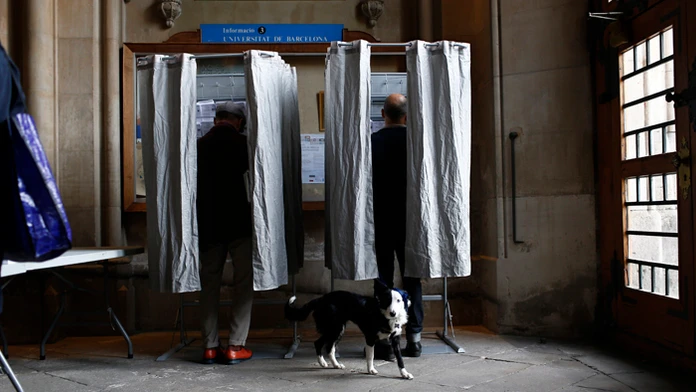 Pes čaká pred hlasovacími plentami počas predčasných regionálnych volieb.