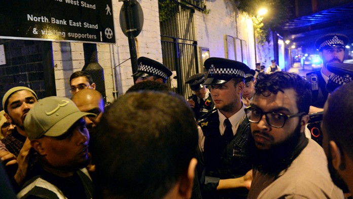 Policajti sa rozprávajú s miestnymi, čo videli incident.