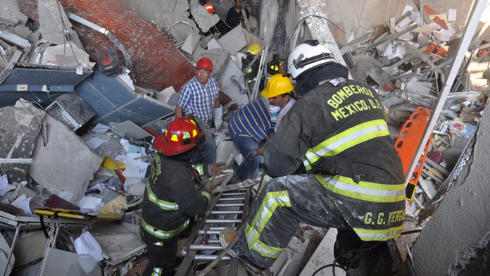 Požiarnici prehľadávajú trosky po výbuchu v centrále mexického štátneho ropného koncernu Petroleos  Mexicanos.