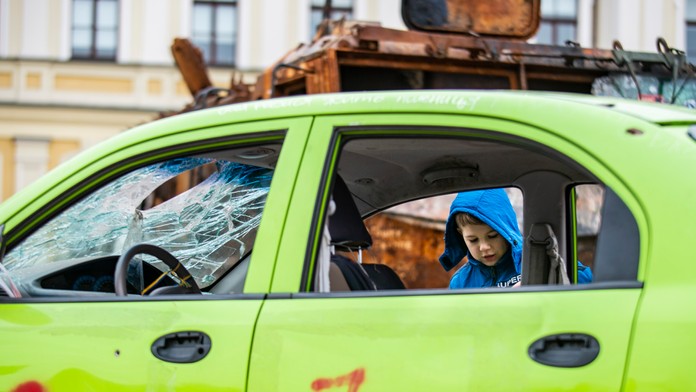Na snímke dieťa stojí pri vrakoch ruských tankov, ktoré sú vystavené pred pravoslávnym Chrámom sv. Michala v Kyjeve