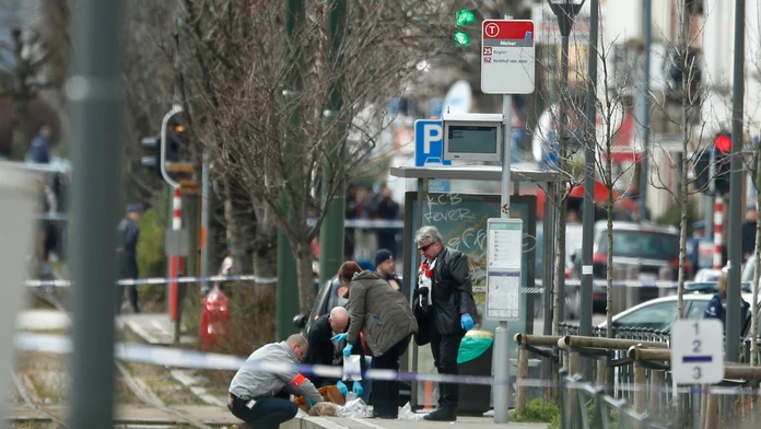 Policajní vyšetrovatelia zaisťujú stopy na električkovej zastávke počas policajnej akcie v belgickej štvrti Schaerbeek
