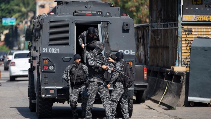 Policajti vystupujú z obrneného vozidla počas operácie proti obchodníkom s drogami vo favele Jacarezinho v Riu de Janeiro.