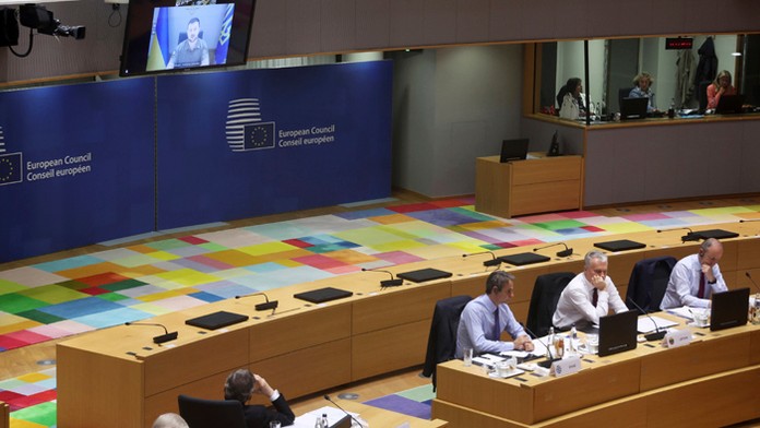 Ukrajinský prezident Volodymyr Zelenskyj (na obrazovke) sa prihovára z Kyjeva počas dvojdňového mimoriadneho summitu EÚ.