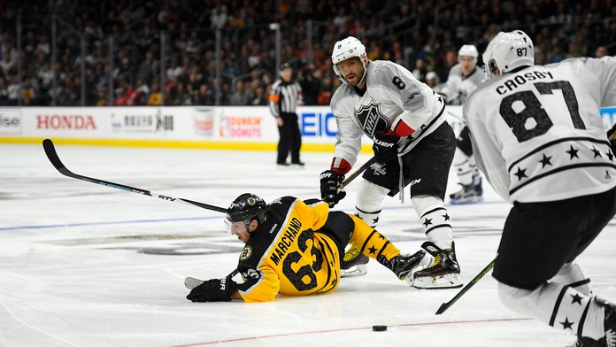 Útočník Atlantickej divízie Brad Marchand leží na ľade po strete s Alexandrom Ovečkinom, Sidney Crosby s pukom (vpravo).