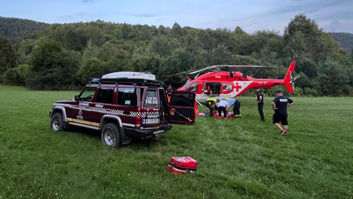 Vrtuľník a horskí záchranári pomáhajú zranenému traktoristovi.