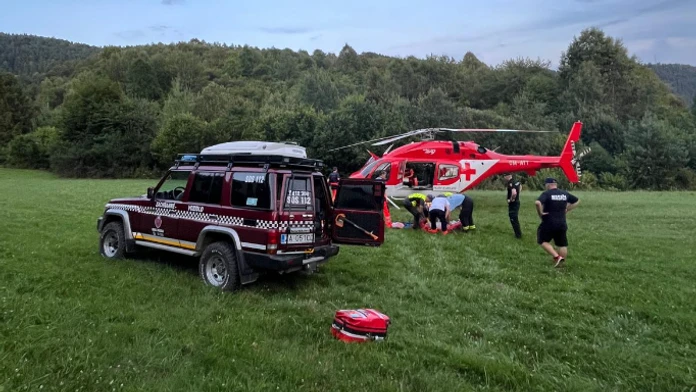 Vrtuľník a horskí záchranári pomáhajú zranenému traktoristovi.