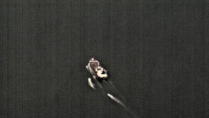 Na videosnímke tri plavidlá  iránskych revolučných gárd prenasledujú obchodné plavidlo v Hormuzskom prielive.