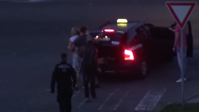 Mestský policajt sa prizerá ako dievča nakladajú do kufra