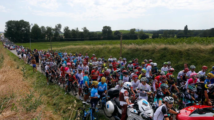 Cyklisti čakajú po tom, čo 16. etapu Tour de France prerušil protest farmárov.