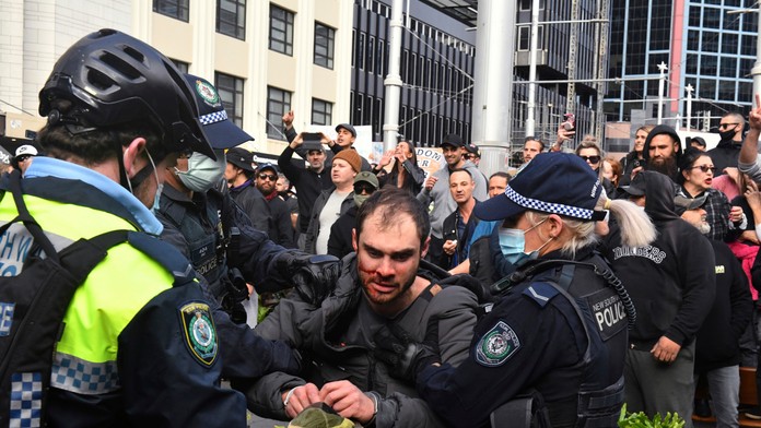 Policajti zadržujú protestujúceho počas demonštrácie proti lockdownu 24. júla 2021 v Sydney.