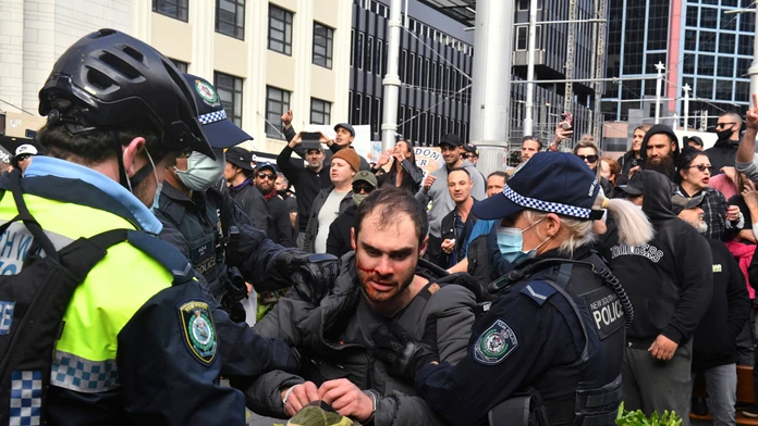Policajti zadržujú protestujúceho počas demonštrácie proti lockdownu 24. júla 2021 v Sydney.