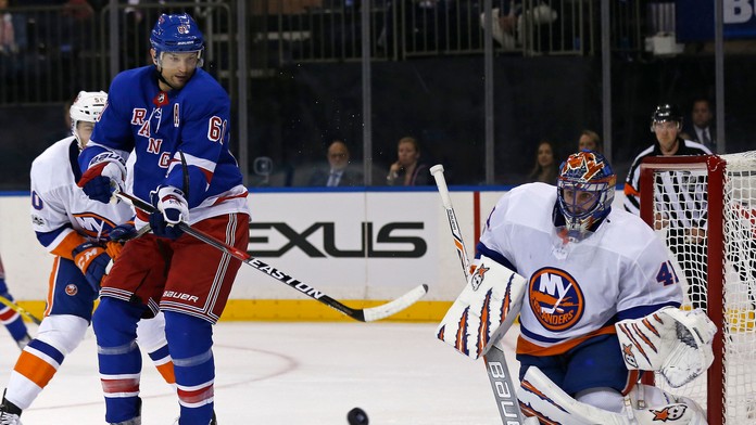 Brankár New Jaroslav Halák vyráža strelu pred Rickom Nashom New Yorku Rangers v príprave pred sezónou NHL.