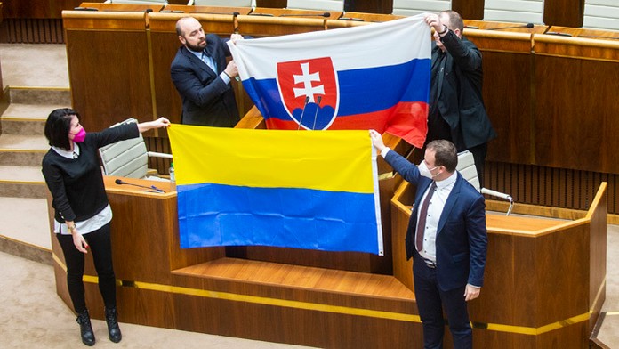 Zľava Andrej Medvecký, Peter Krupa (obidvaja ĽSNS) držia slovenskú vlajku a dole Jana Bittó Cigániková a Miroslav Žiak (obidvaja