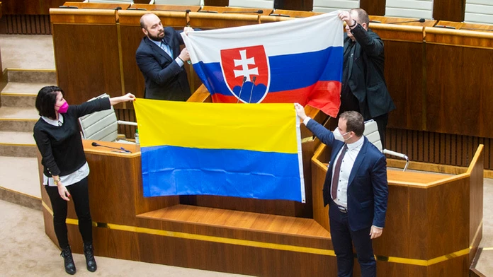 Zľava Andrej Medvecký, Peter Krupa (obidvaja ĽSNS) držia slovenskú vlajku a dole Jana Bittó Cigániková a Miroslav Žiak (obidvaja