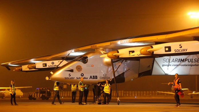 Na snímke členovia tímu tlačia švajčiarske experimentálne lietadlo Solar Impulse-2.